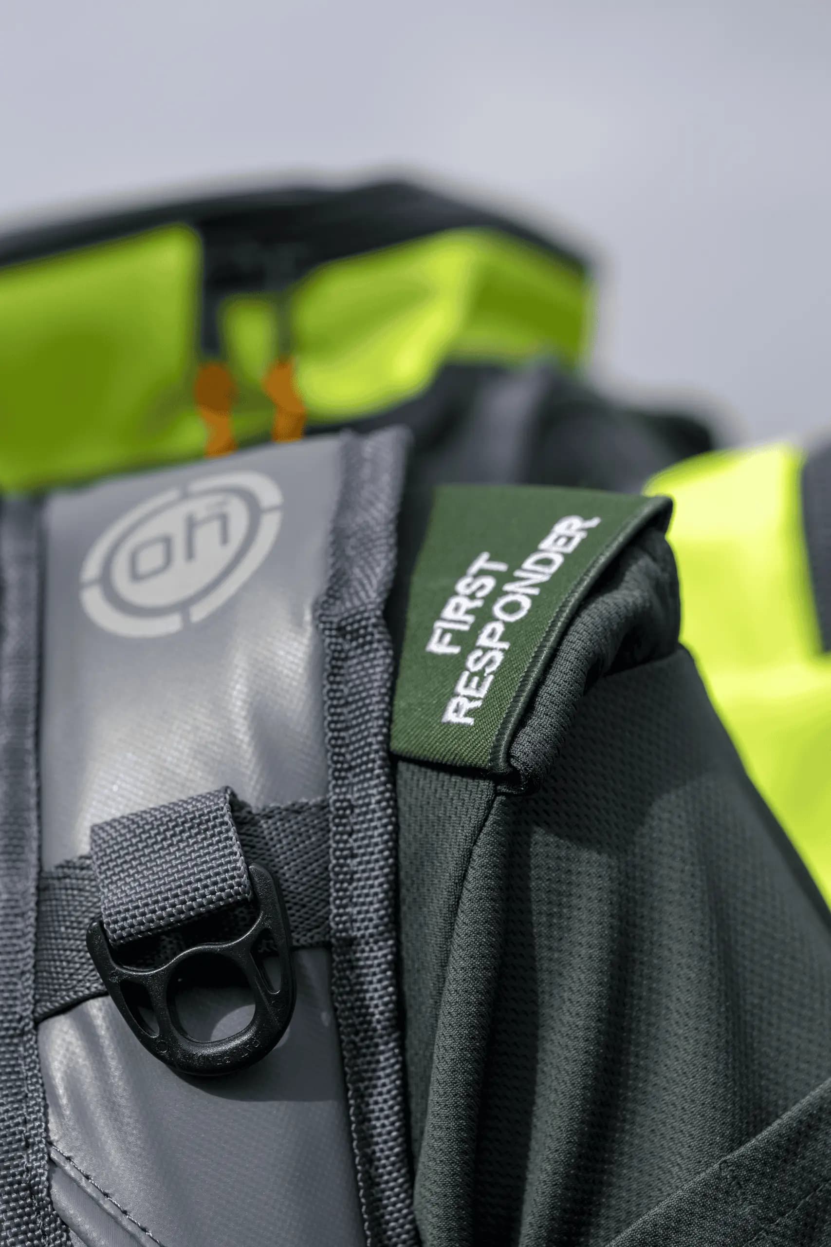 Close-up of a first responder medical kit with high-visibility equipment in the background.