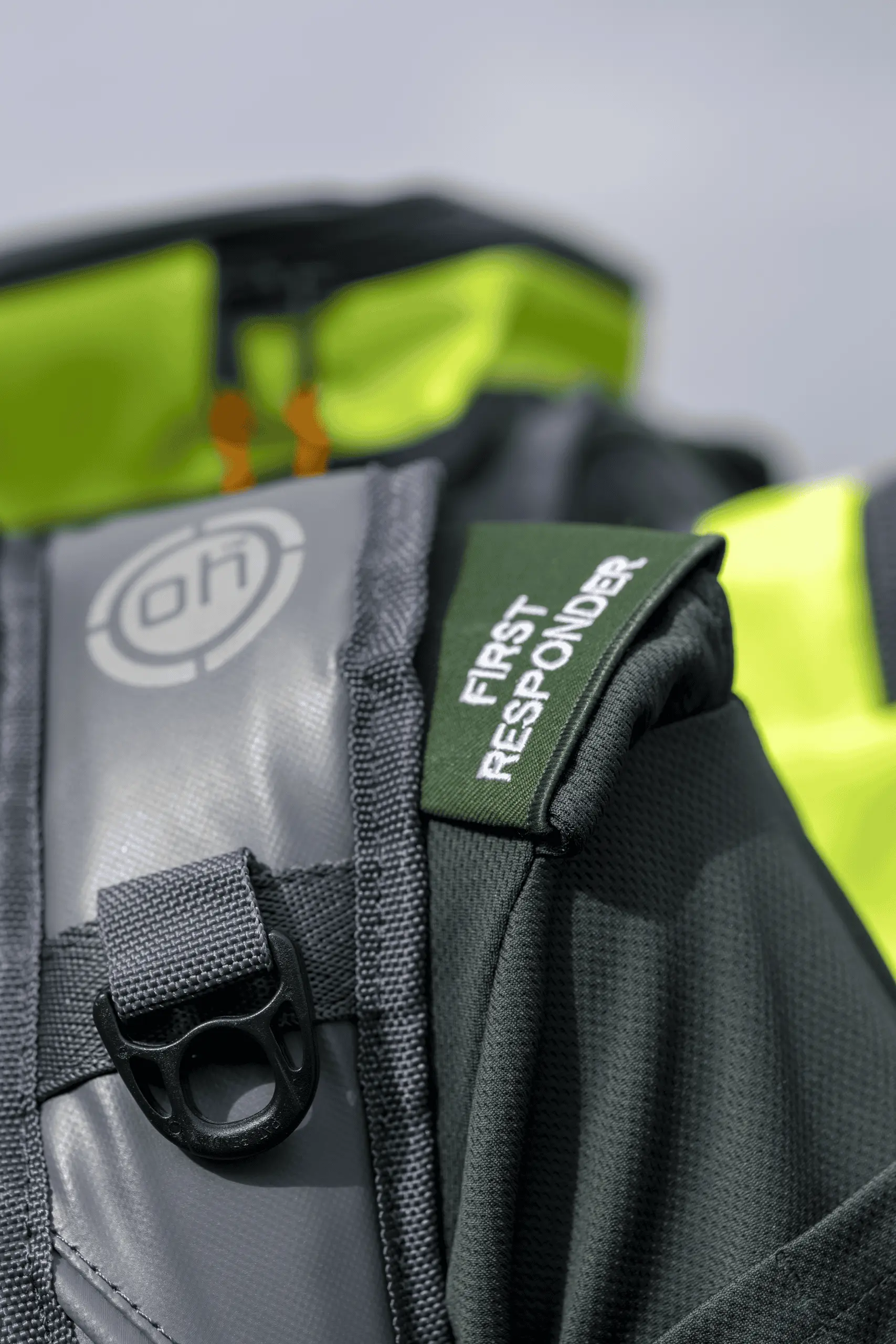 Close-up of a first responder medical kit with high-visibility event equipment in the background.